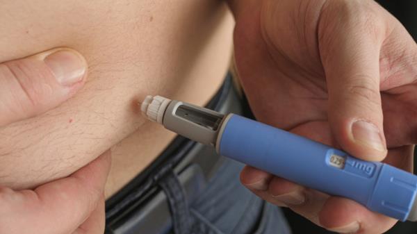 Man injects himself with weight loss drug. 
