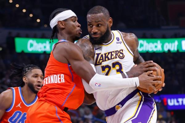 Los Angeles Lakers forward LeBron James, right, drives as Oklahoma City Thunder guard Shai Gilgeous-Alexander defends during the first half of an NBA basketball game Saturday, Dec. 23, 2023