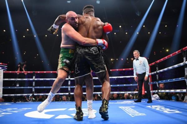 Tyson Fury holds o<em></em>nto Francis Ngannou during their Heavyweight fight