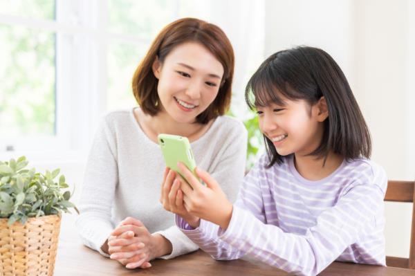 Mother and daughter looking at smart phone.