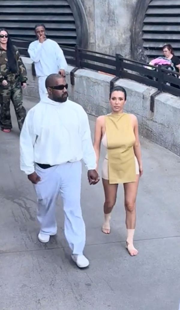 Kanye West and Bianca Censori visiting Disneyland, with Bianca walking shoeless and with bandaged feet