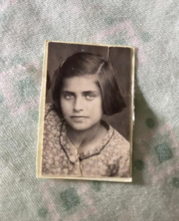 A photo of Lucy Lipiner as a young girl, with the photo placed upon a piece of green fabric