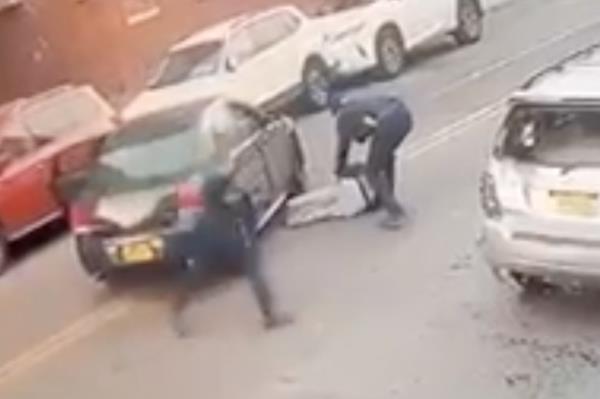 A cops tends to the injured teen in Queens.