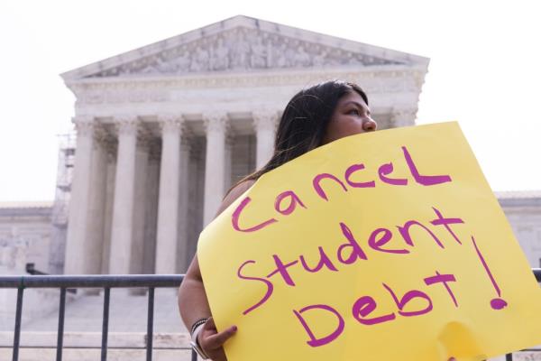 Supporters of student loan forgiveness check for news on United States Supreme Court decisions outside the Supreme Court in Washington, DC.