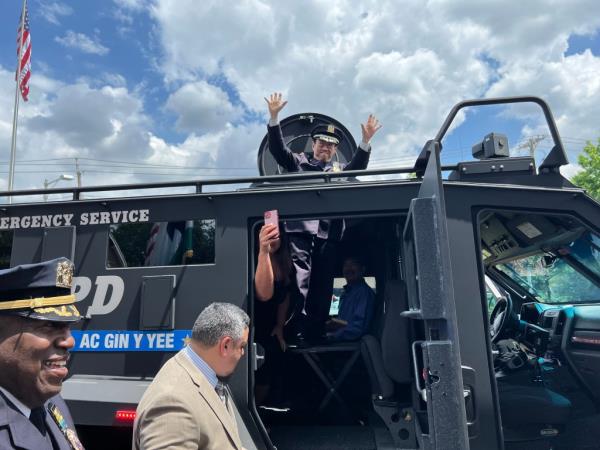 Yee waving goodbye from the top of an NYPD vehicle during his retirement ceremony.