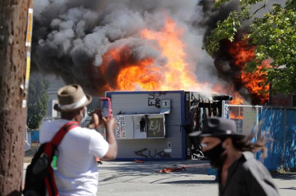 Co<em></em>nstruction buildings burn near the King County Juvenile Detention Center, Saturday, July 25, 2020, in Seattle, shortly after protesters left the area. A large group of protesters were marching Saturday in Seattle in support of Black Lives Matter and against police brutality and racial injustice. Protesters broke windows and vandalized cars at the facility. 