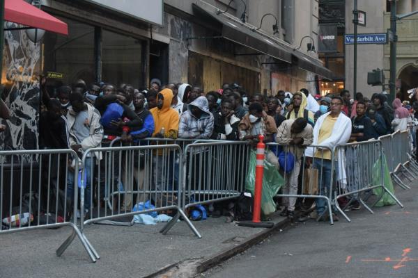 Migrants stand on line at the Roosevelt Hotel.