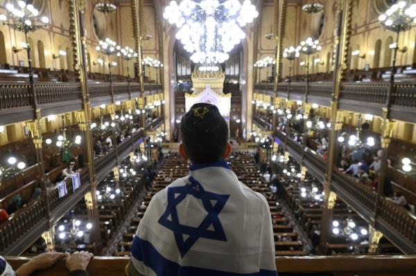 A man with an Israeli flag attends a solidarity service for the Israeli victims of the deadly attacks by the Palestinian terrorist group Hamas at Dohany Street Synagogue in Budapest on Oct. 11, 2023. 