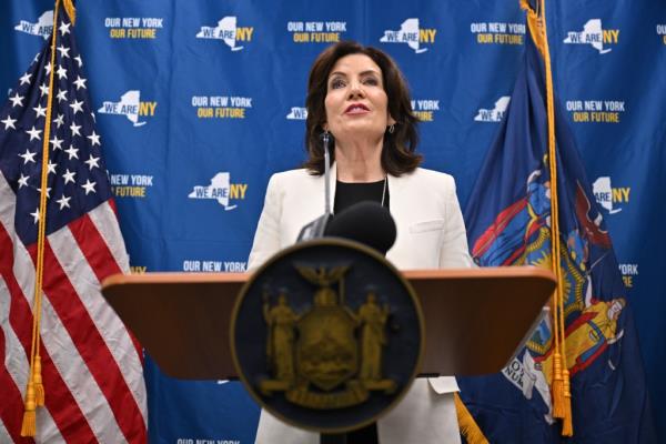 NYS Governor Kathy Hochul standing at a podium during housing announcement, surrounded by advocates and officials, Manhattan NYC