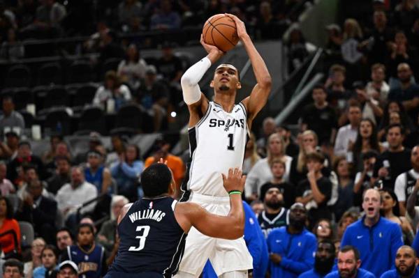 San Anto<em></em>nio Spurs' French forward-center #01 Victor Wembanyama shoots the ball past Dallas Mavericks' US power forward #03 Grant Williams 