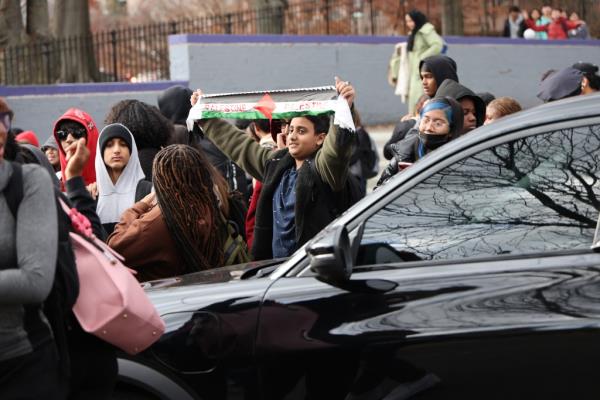 Hillcrest High School students hold up a banner reading, 