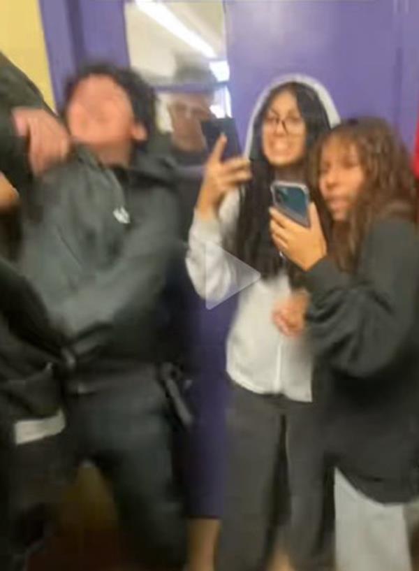 screenshot from a tiktok video showing students holding up their cellphones