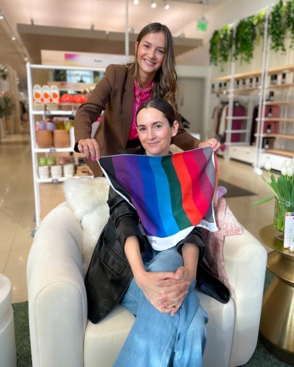 Mariana Marques holds up a color swatch in front of a female client. 