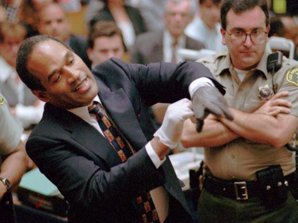 Simpson attempting to put on one of the gloves prosecutors claimed he wore during the murders.
