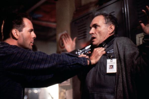 Bruce Willis pointing a gun at Tom Bower