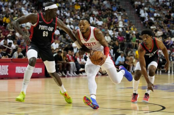 Houston Rockets' Cam Whitmore drives against Portland Trail Blazers' Duop Reath, left, and Portland Trail Blazers' Scoot Henderson, right, during the first half of an NBA summer league basketball game Friday, July 7, 2023, in Las Vegas.