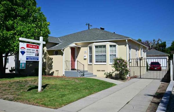 For Sale sign posted in front of a single-family home in San Marino, California.
