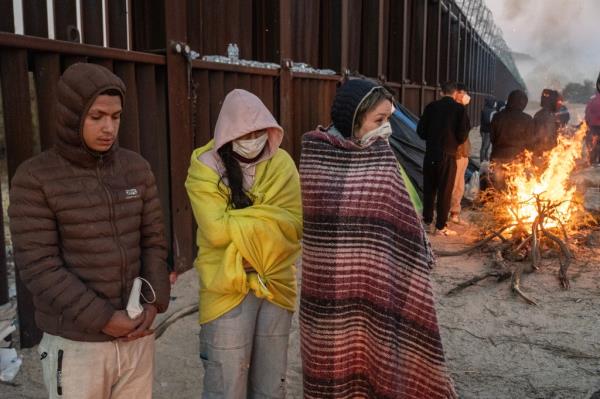 Migrants at the US border wall. 