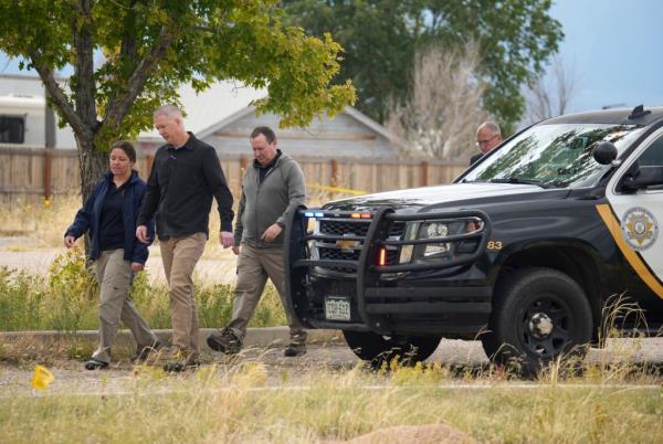 Authorities walk outside a closed funeral home