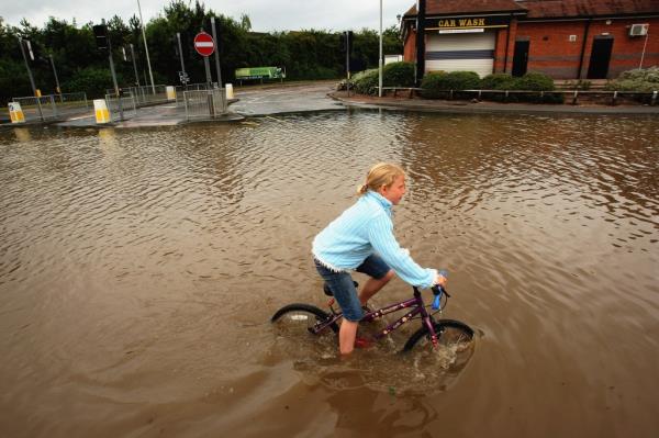 A young girl rides her bike through floodwaters in Tewkesbury, England in July 2007.