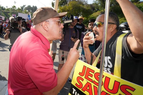 Protesters are seen yelling in each others faces outside Dodgers stadium on June 16, 2023.