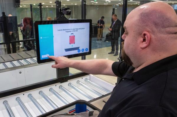 A worker checking a bag screening. 