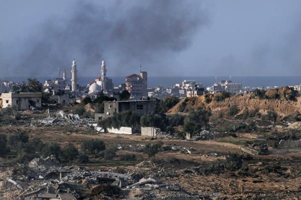 Israeli army vehicles operate on the edge of the Gaza Strip, seen from southern Israel on Jan.13, 2024.