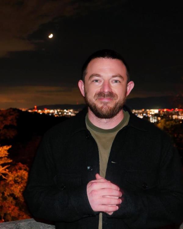 Michael Latt poses for a photo along a skyline.