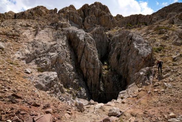 A Turkish officer walks next to the Morca cave during a rescue operation near Anamur, south Turkey, Saturday, Sept. 9, 2023. American researcher Mark Dickey, 40, who fell ill almost 1,000 meters (more than 3,000 feet) below the entrance of a cave in Turkey, has recovered sufficiently enough to be extracted in an operation that could last three or four days, a Turkish official was quoted as saying on Friday. (AP Photo/Khalil Hamra)