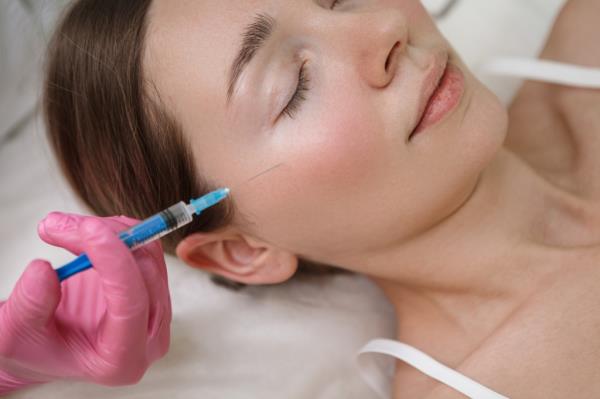 Woman getting face filler injections. 