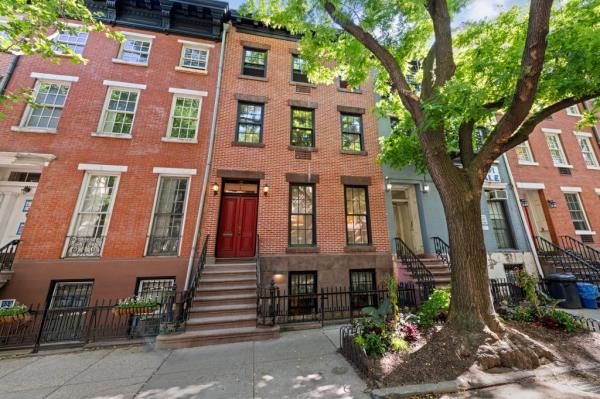 The open chef's kitchen with its retro red fridge and mustard yellow cabinetry hasn't changed since Ethan Hawke's time in the townhouse.