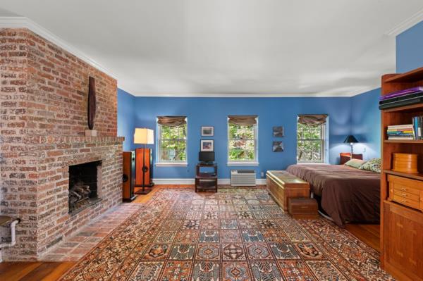 A brick fireplace in a main bedroom. 