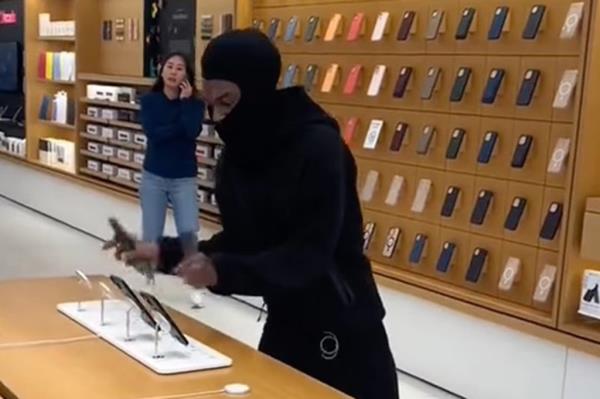 A person in black mask stealing iPho<em></em>nes at an Apple Store. (@bustdowncorn/LOCAL NEWS X /TMX)