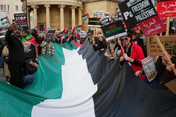 LONDON, ENGLAND - OCTOBER 14: Supporters of Palestine carry a large Palestinian flag during a rally in Lo<em></em>ndon to co<em></em>ndemn the recent fighting in Gaza on October 14, 2023 in London, United Kingdom. Groups supporting Palestine protest at Israel's retaliation to Hamas attacks across the UK this weekend despite the Home Secretary, Suella Braverman, suggesting that waving Palestinian flags and using popular pro-Palestine slogans could be illegal under the Public Order Act in a letter she sent to police chiefs in England and Wales on Tuesday. (Photo by Carl Court/Getty Images)