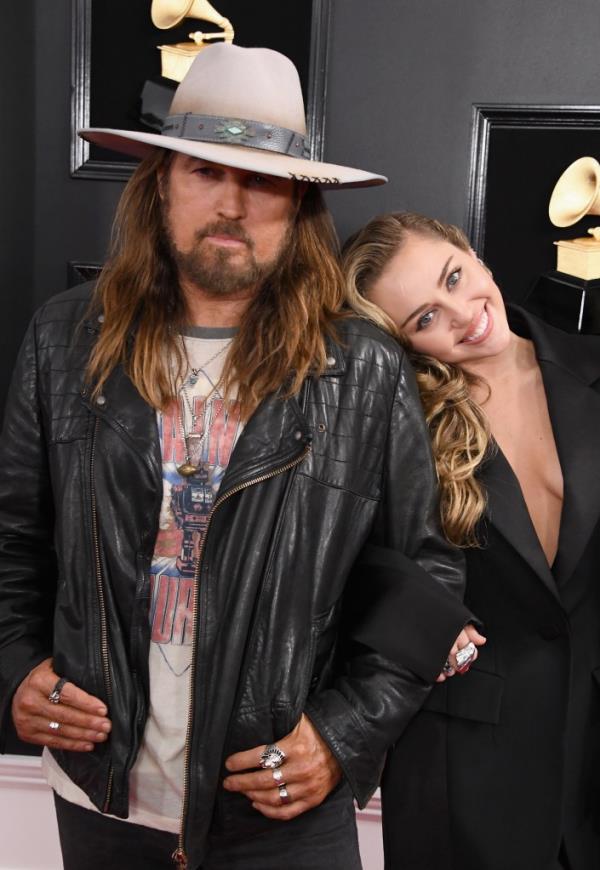 Miley Cyrus smiling with her dad, Billy Ray Cyrus. 