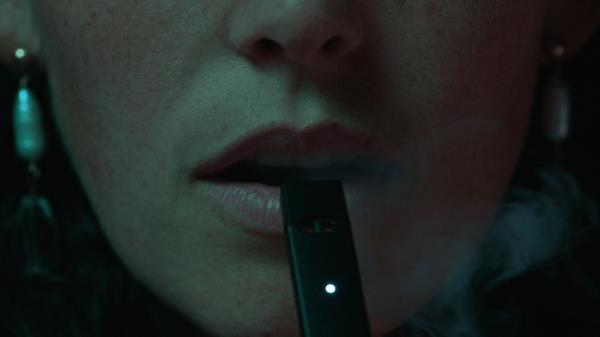 A mouth with an e-cigarette in it. 