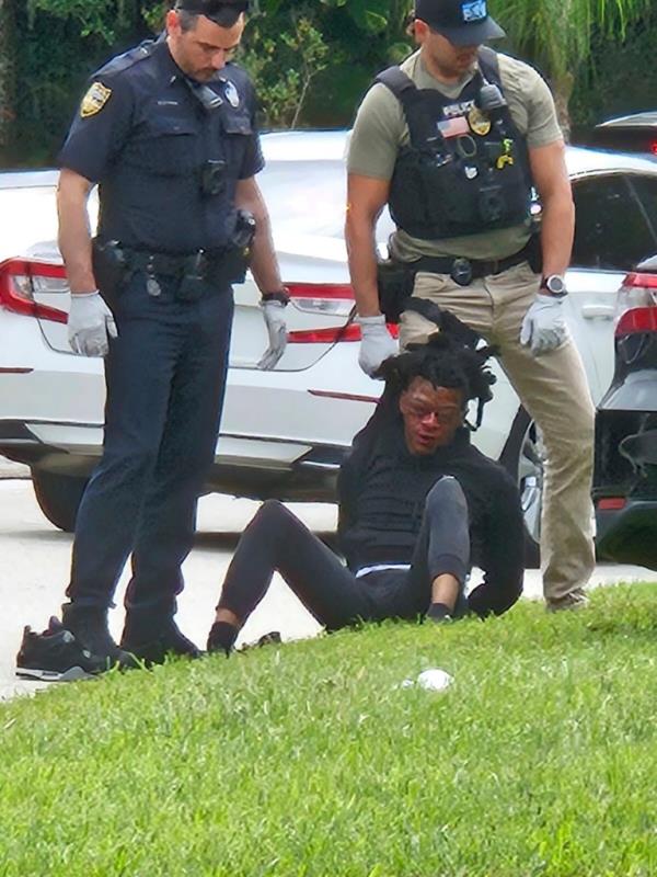 cellphone video provided by Ruby Anderson shows LeaKeian Woods, with swollen eyes and a bloody face sitting on the ground surrounded by officers, as he's taken into custody, Friday, Sept. 29, 2023, in northeast Florida.
