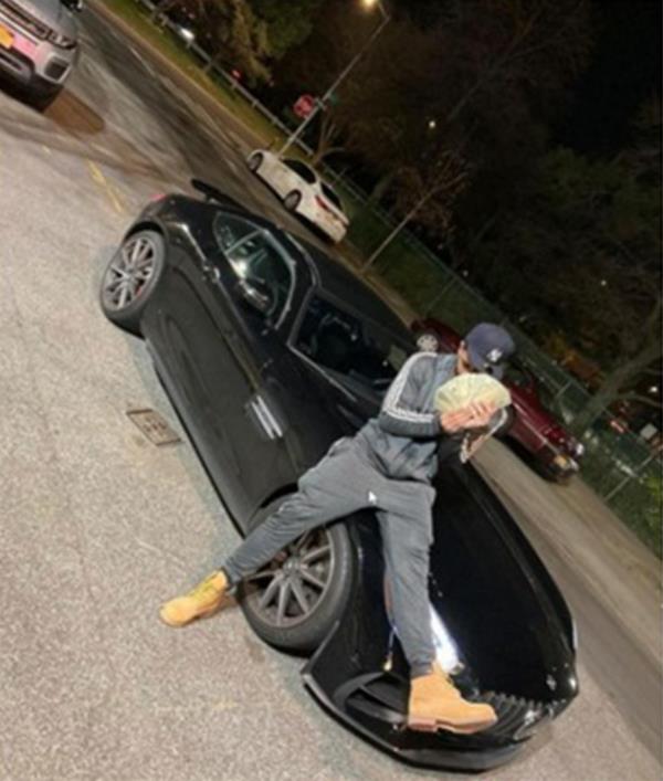 Man sitting on hood of car with cash