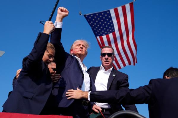 Former President Do<em></em>nald Trump surrounded by U.S. Secret Service agents at a campaign rally in Butler, Pennsylvania in 2024
