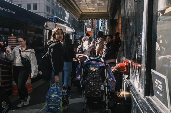 Migrants line up outside the storied hotel. 