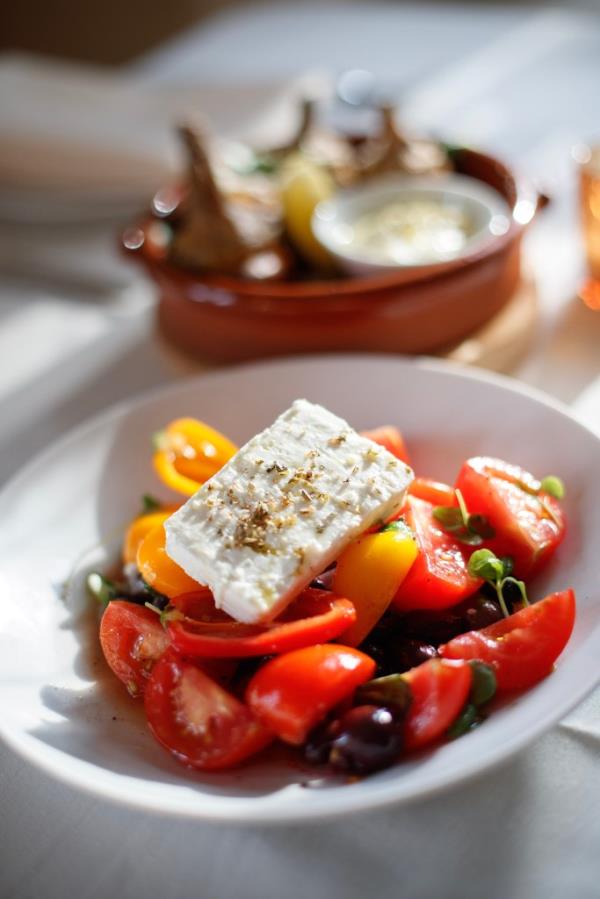 The Greek Salad made with ripe tomatoes, basil, oregano, red onion, feta cheese, Taggiasca olives, and sweet peppers.