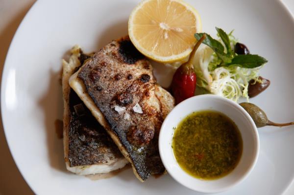 A whole debo<em></em>ned and roasted branzino with Salmoriglio sauce. 