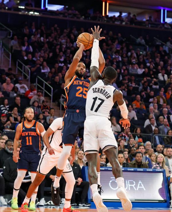 New York Knicks forward Mikal Bridges puts up a shot over Brooklyn Nets guard Dennis Schroder in the first half at the Madison Square Garden in New York, USA, Friday, November 15, 2024.