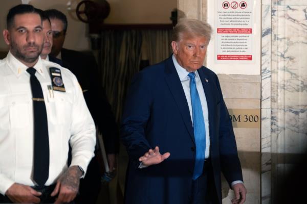 Trump waving after returning to court after a break in his trial.