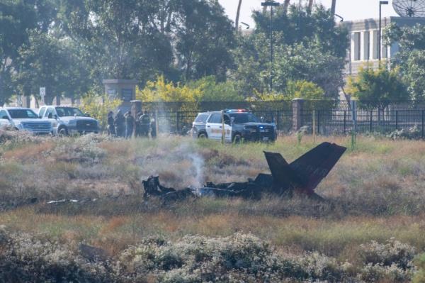 tthe wreckage of the crashed small plane, and nearby police, are pictured.