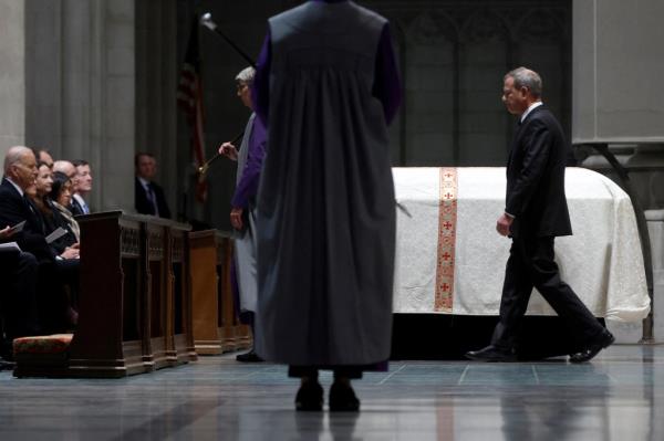 U.S. Chief Justice John Roberts attends the funeral service as guests walk by her casket.