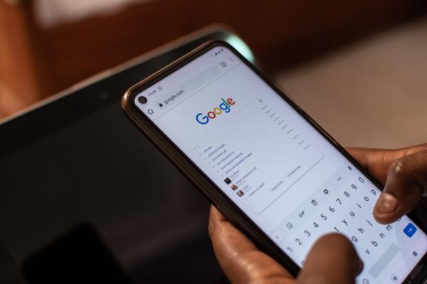 A black person in Auchi, Edo-Nigeria, using a smartphone to perform a Google search on June 12, 2021