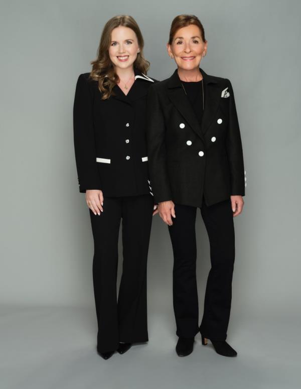 Sarah Rose standing next to Judge Judy Sheindlin both wearing similar black pantsuits. 