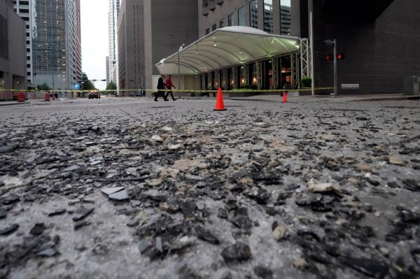 Broken glass covers a downtown street in the aftermath of a severe thunderstorm Friday, May 17, 2024, in Houston.