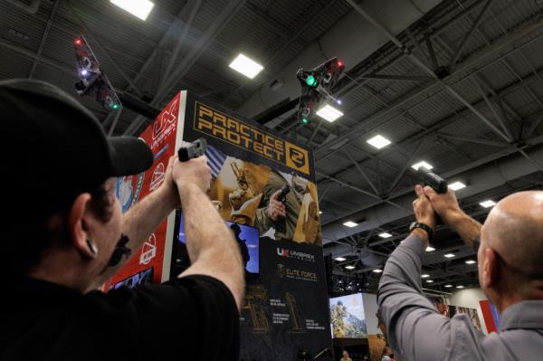 People practice their shot with laser technology at an exhibition booth during the annual Natio<em></em>nal Rifle Association (NRA) meeting in Dallas, Texas, U.S., May 18, 2024